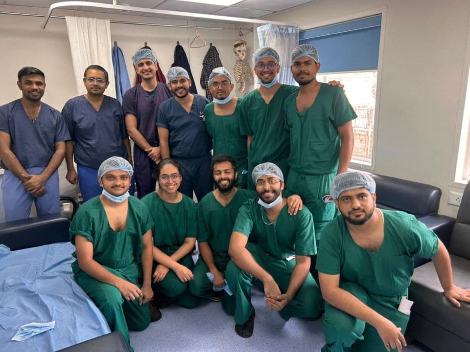 Dr Nikhil Oza with surgeons and residents in green scrubs
